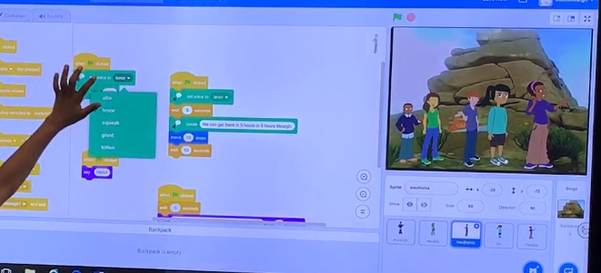 Student at interactive whiteboard leading collaborative debugging of code.